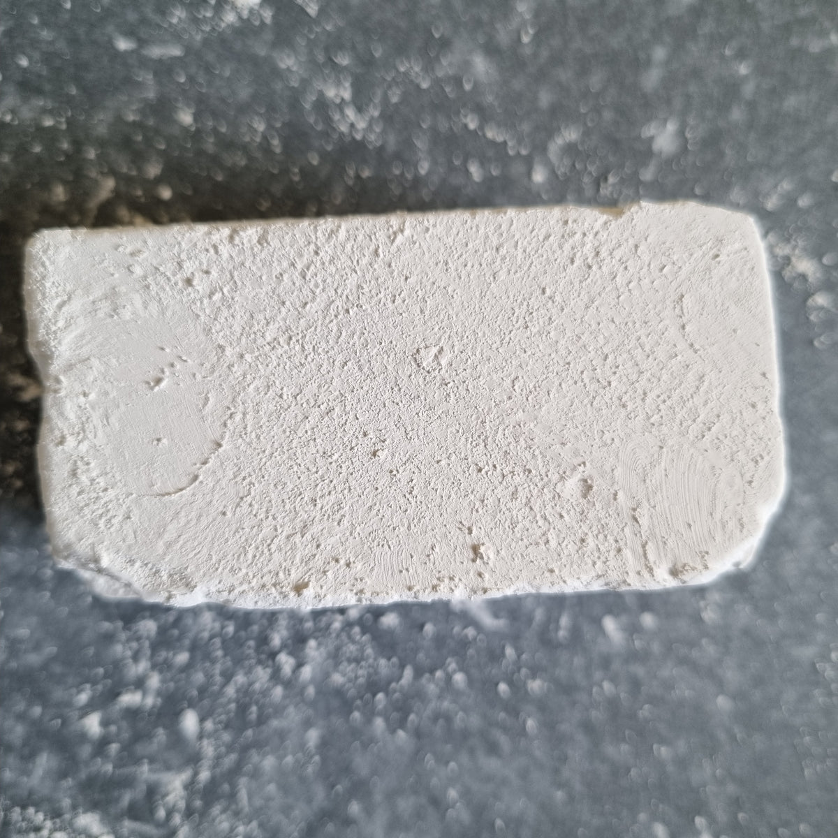 Top view of a rectangular white Dobryj chalk block on a dark tray