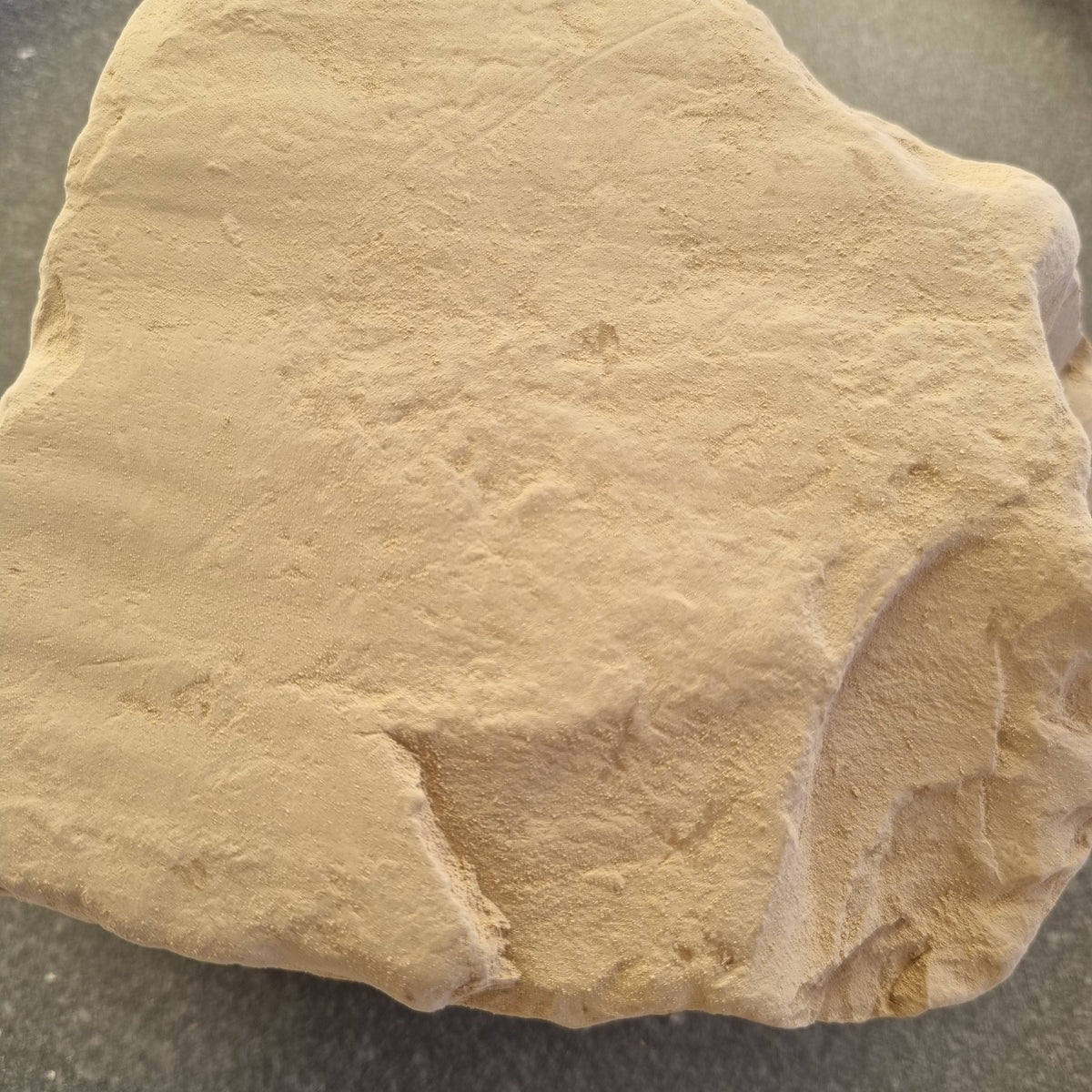 Close-up of a beige Turkestan Plitki clay slab with an uneven surface and irregular edges
