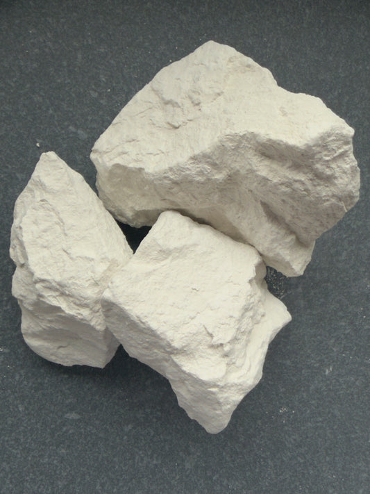 Three pieces of DACHNY natural chalk on a dark background