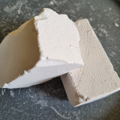 Two broken pieces of white Dobryj chalk showing their inner texture