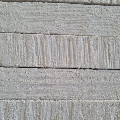 White Kristall natural chalk bars stacked in horizontal rows, with textured surfaces and visible grooves.
