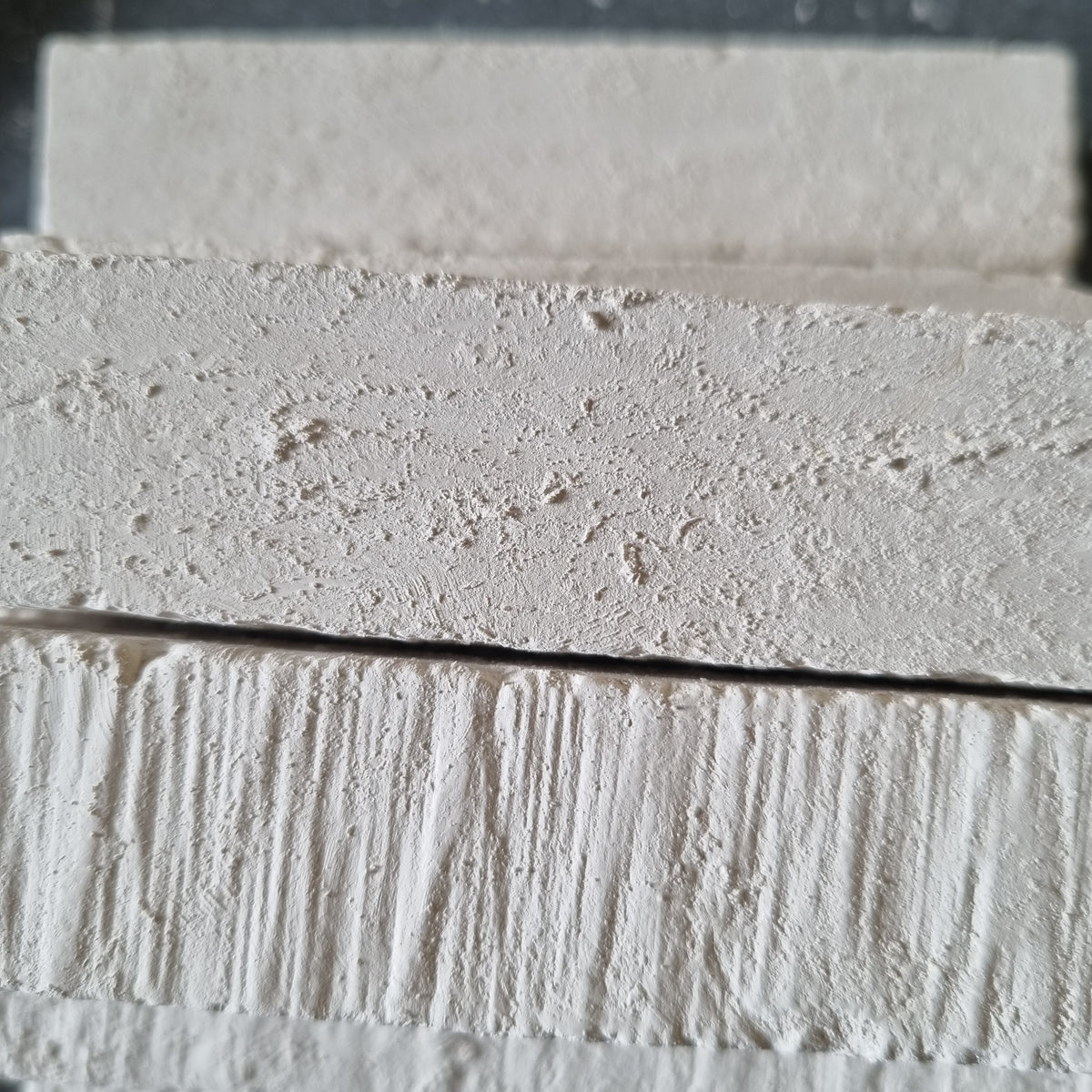 Close-up of stacked white Kristall natural chalk bars showing rough surfaces and fine grooves.