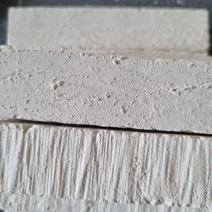 Close-up of stacked white Kristall natural chalk bars showing rough surfaces and fine grooves.
