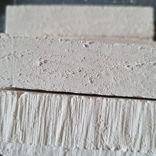 Close-up of stacked white Kristall natural chalk bars showing rough surfaces and fine grooves.
