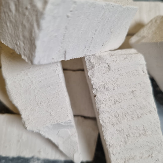 Stacked New Oskol natural white chalk pieces with rough surfaces and uneven broken edges.