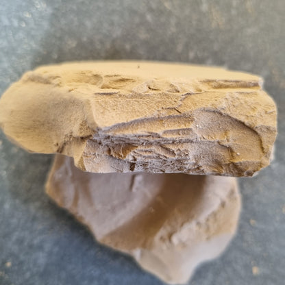 Side view of stacked Turkestan Plitki clay pieces showing layered fracture edges