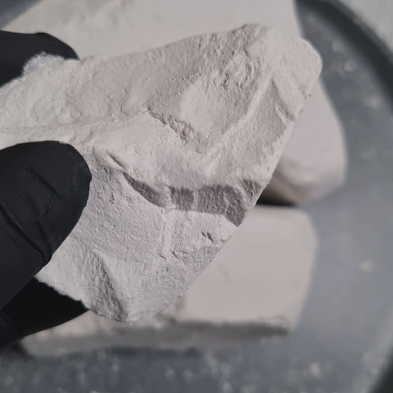 Close-up of Premium white chalk held in a black-gloved hand