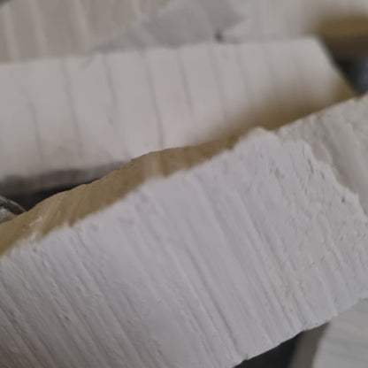 Close-up of a Vatutin white chalk piece with fine surface ridges and an uneven edge.